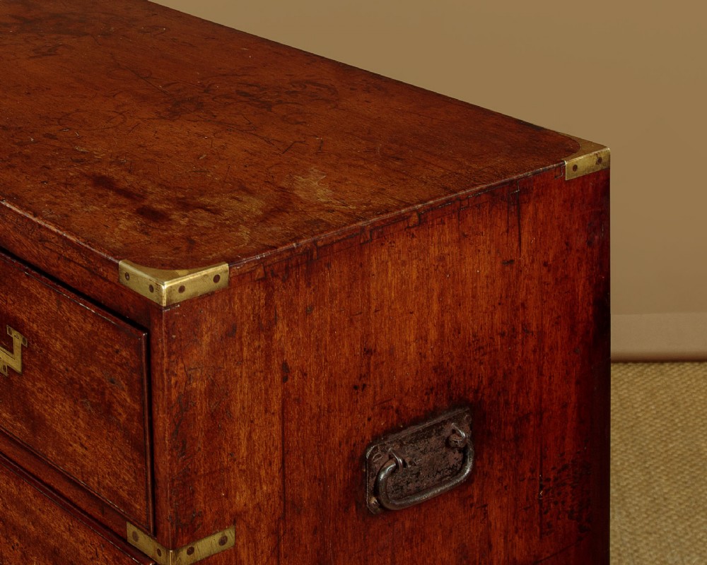 A Victorian mahogany military campaign chest featuring brass corner bindings, flush handles, two short drawers over three long drawers, resting on turned feet. View VI