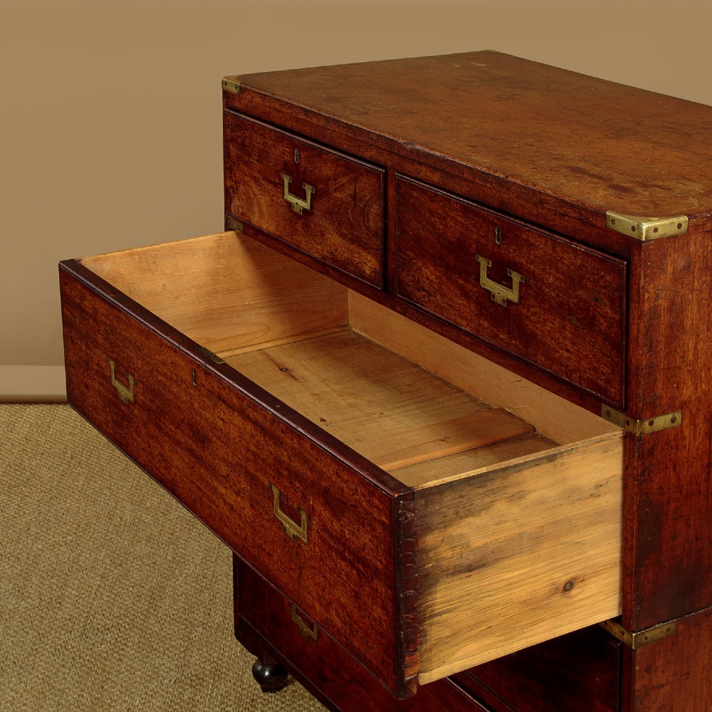 A Victorian mahogany military campaign chest featuring brass corner bindings, flush handles, two short drawers over three long drawers, resting on turned feet. View VIII