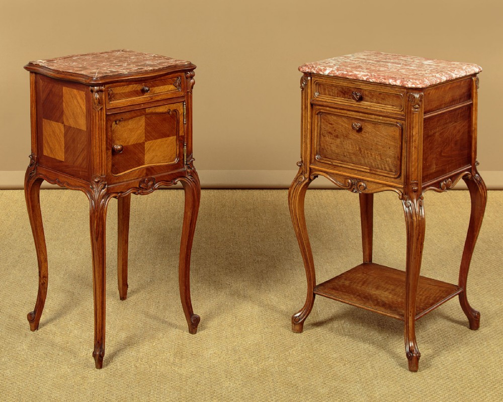A pair of early twentieth-century walnut bedside cabinets featuring carved cabriole legs and pink variegated marble tops.