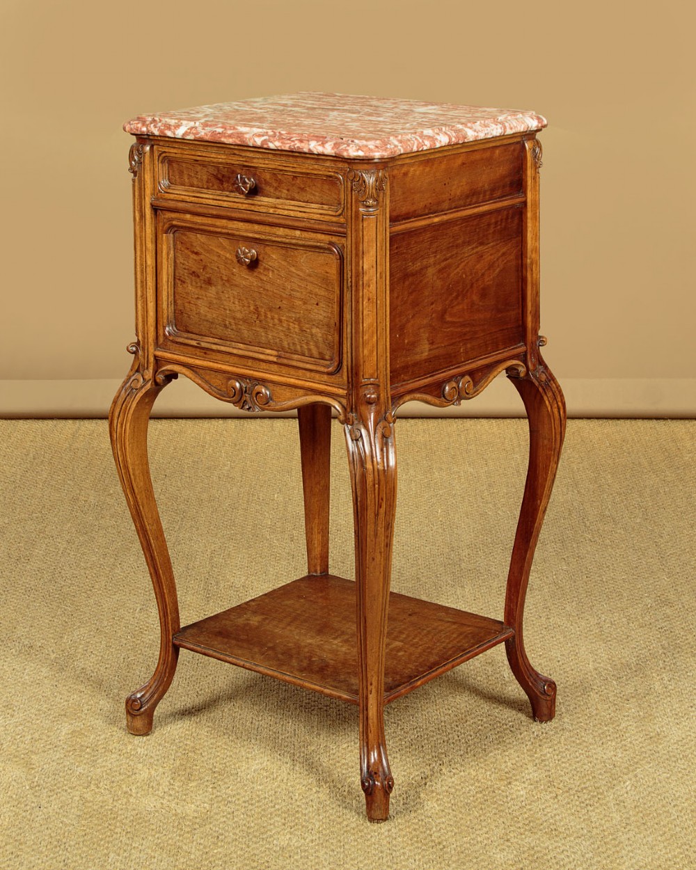 A pair of early twentieth-century walnut bedside cabinets featuring carved cabriole legs and pink variegated marble tops. View VI