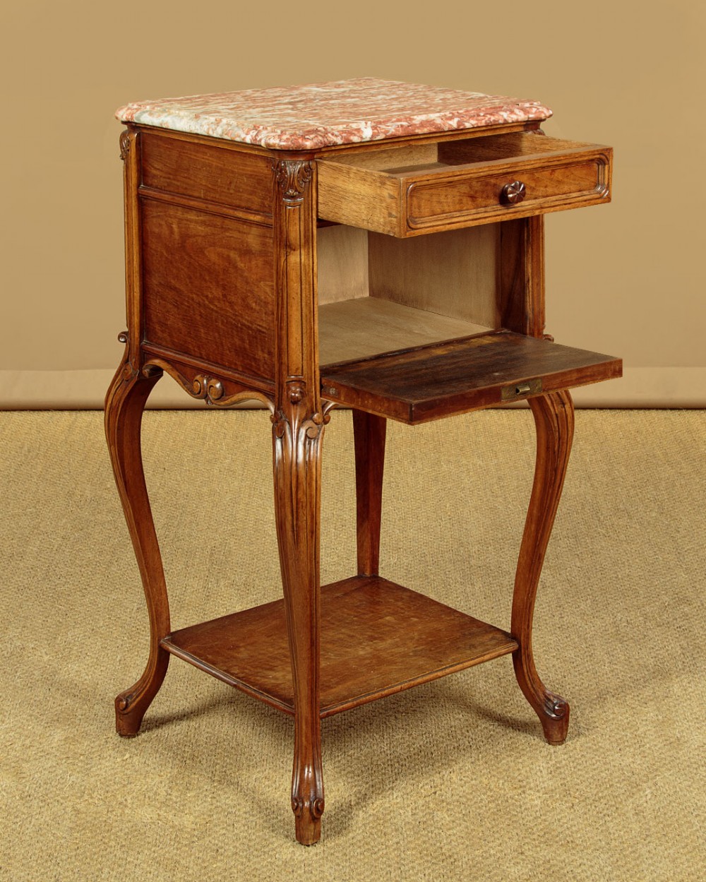 A pair of early twentieth-century walnut bedside cabinets featuring carved cabriole legs and pink variegated marble tops. View VII