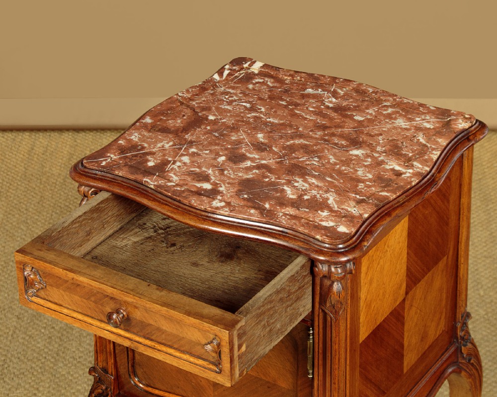 A pair of early twentieth-century walnut bedside cabinets featuring carved cabriole legs and pink variegated marble tops. View VIII