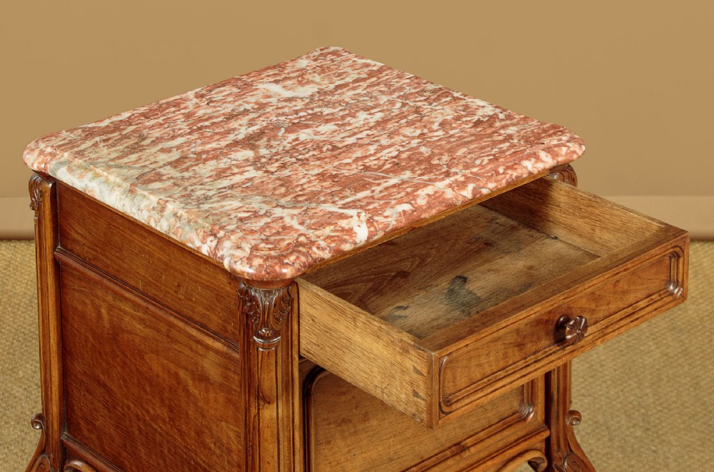 A pair of early twentieth-century walnut bedside cabinets featuring carved cabriole legs and pink variegated marble tops. View IX