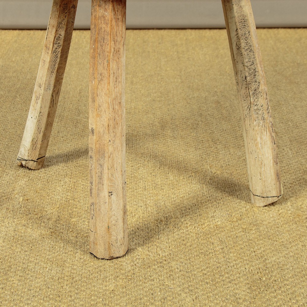 A rustic French provincial elm chopping block featuring a thick cylindrical wood top with three splayed timber legs. View X