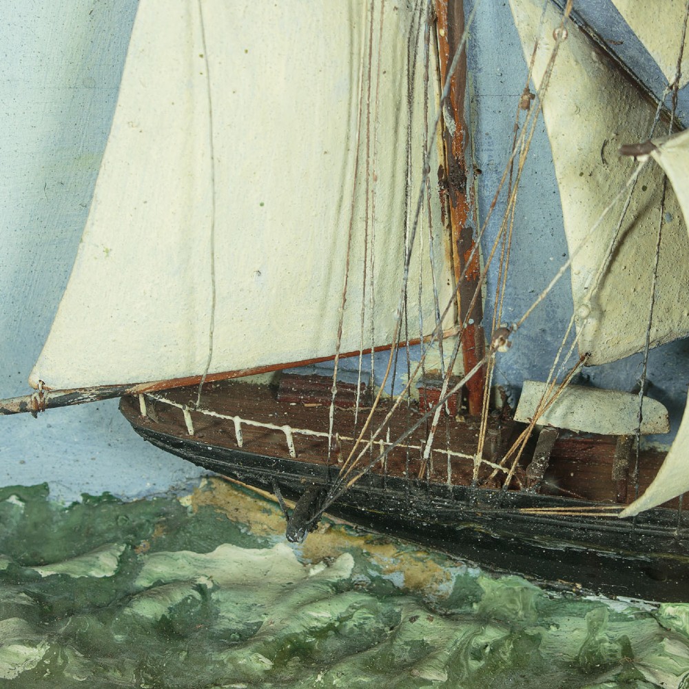 A three-dimensional antique maritime diorama featuring a three-masted sailing ship framed in a deep glazed wooden box with a painted sky and sea background. View V