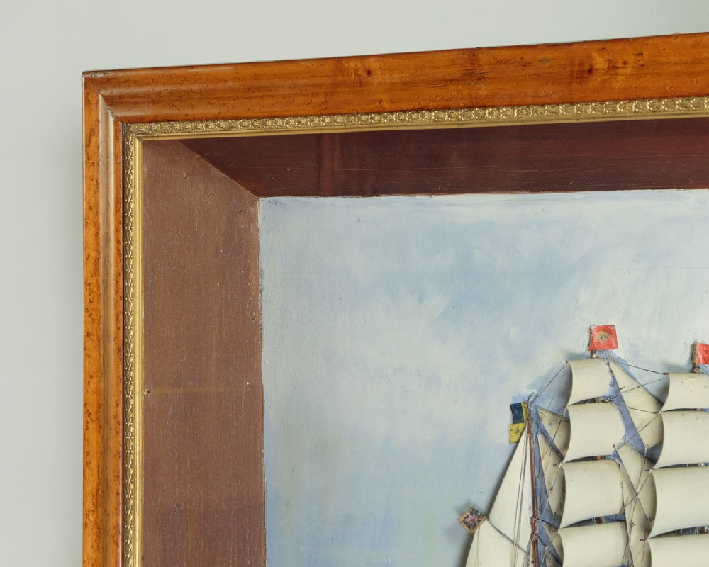 A three-dimensional antique maritime diorama featuring a three-masted sailing ship framed in a deep glazed wooden box with a painted sky and sea background. View XI