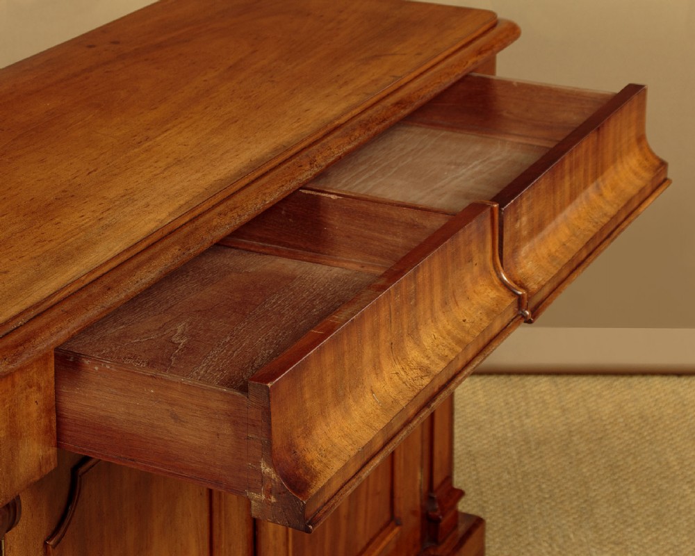 A mid-19th-century Victorian mahogany sideboard featuring a smooth flat top, two frieze drawers, and a pair of panelled cupboard doors flanked by carved corbels. View VIII
