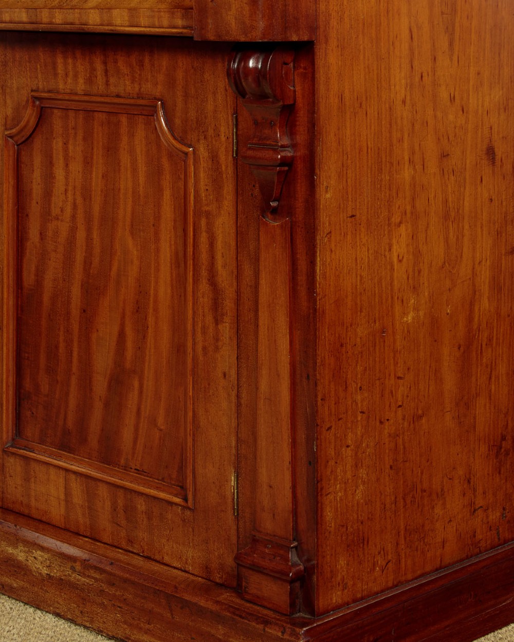 A mid-19th-century Victorian mahogany sideboard featuring a smooth flat top, two frieze drawers, and a pair of panelled cupboard doors flanked by carved corbels. View XI