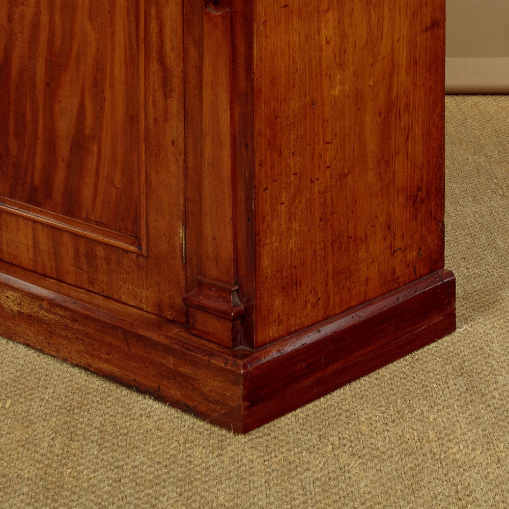 A mid-19th-century Victorian mahogany sideboard featuring a smooth flat top, two frieze drawers, and a pair of panelled cupboard doors flanked by carved corbels. View XII