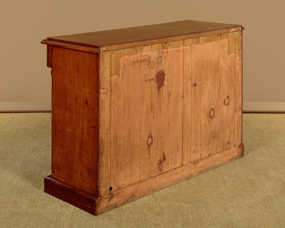 A mid-19th-century Victorian mahogany sideboard featuring a smooth flat top, two frieze drawers, and a pair of panelled cupboard doors flanked by carved corbels. View XIII