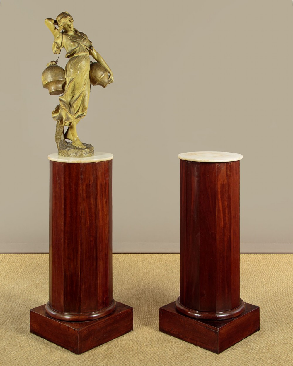 A pair of antique dark mahogany column pedestals featuring circular white marble tops and heavy square plinth bases. View II