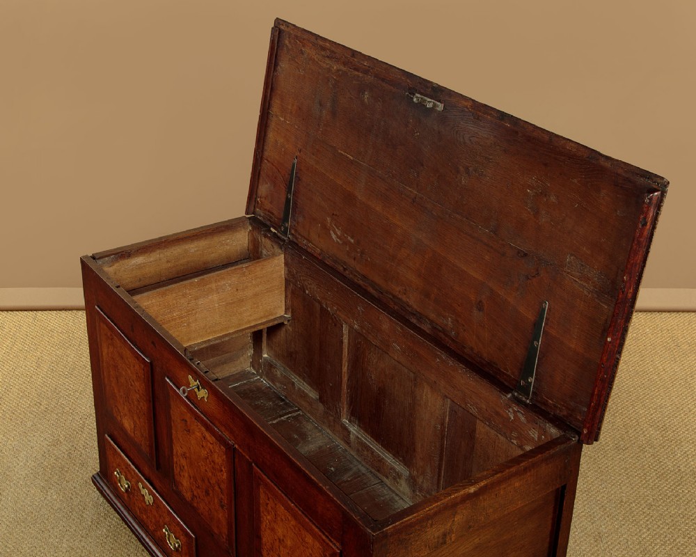 A late eighteenth-century Georgian dark oak mule chest featuring three burr elm inset panels and two lower drawers with brass handles. View IV
