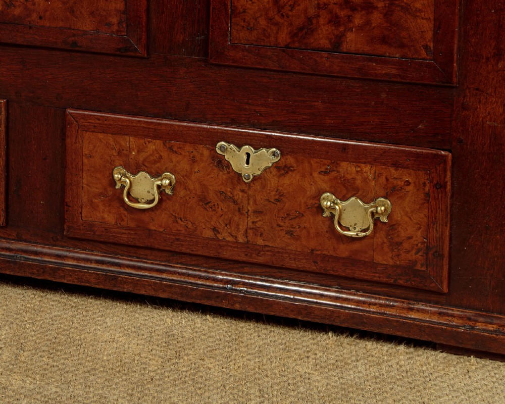 A late eighteenth-century Georgian dark oak mule chest featuring three burr elm inset panels and two lower drawers with brass handles. View IX