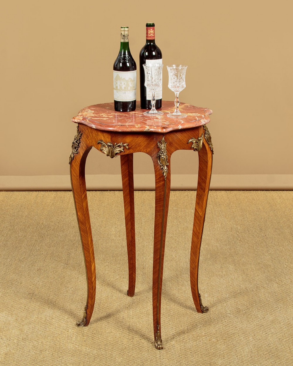 A French Louis XV style wine table with a contoured red marble top, parquetry veneer, metal mounts, and cabriole legs. View II