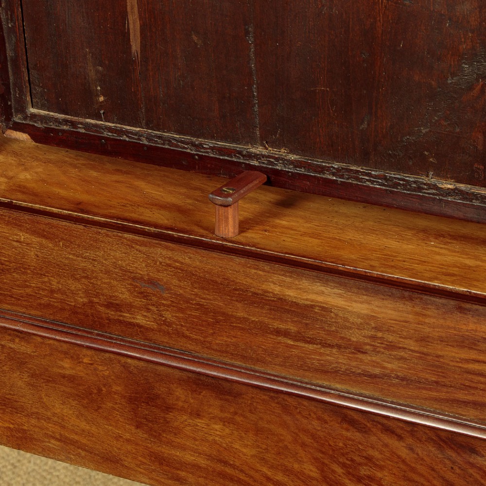 A French Empire flame mahogany dressing table featuring an arched swing mirror flanked by column supports with brass mounts, small trinket drawers, and a pink leather writing surface. View XII