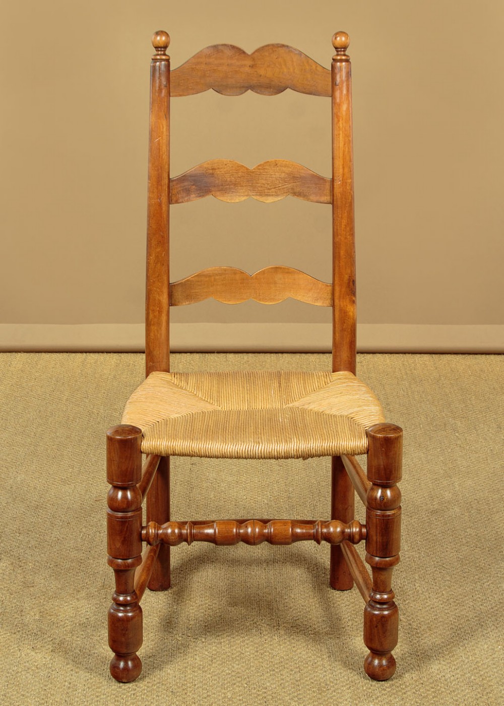 A set of six wooden ladderback dining chairs featuring wavy back slats, turned front legs, and woven rush seats. View III