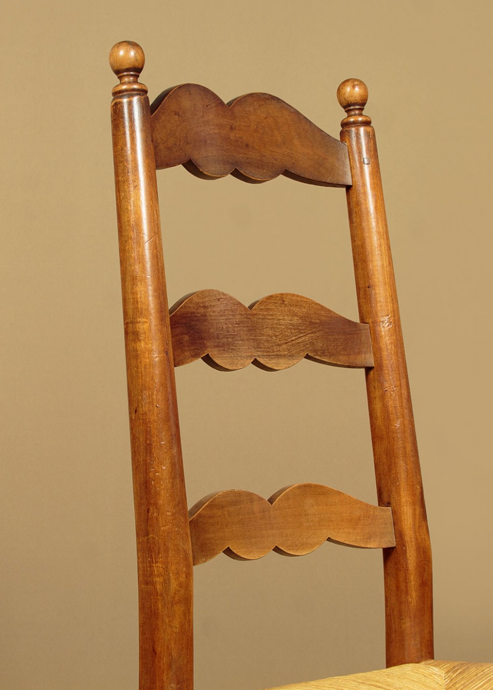 A set of six wooden ladderback dining chairs featuring wavy back slats, turned front legs, and woven rush seats. View IV