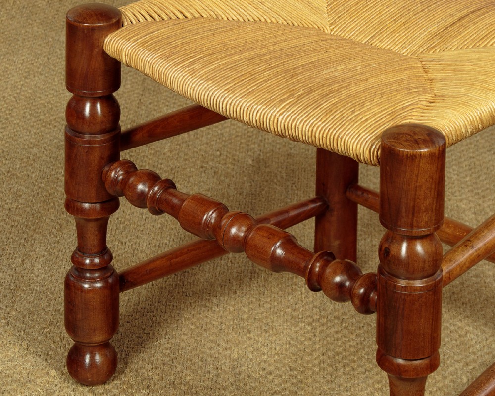 A set of six wooden ladderback dining chairs featuring wavy back slats, turned front legs, and woven rush seats. View VIII