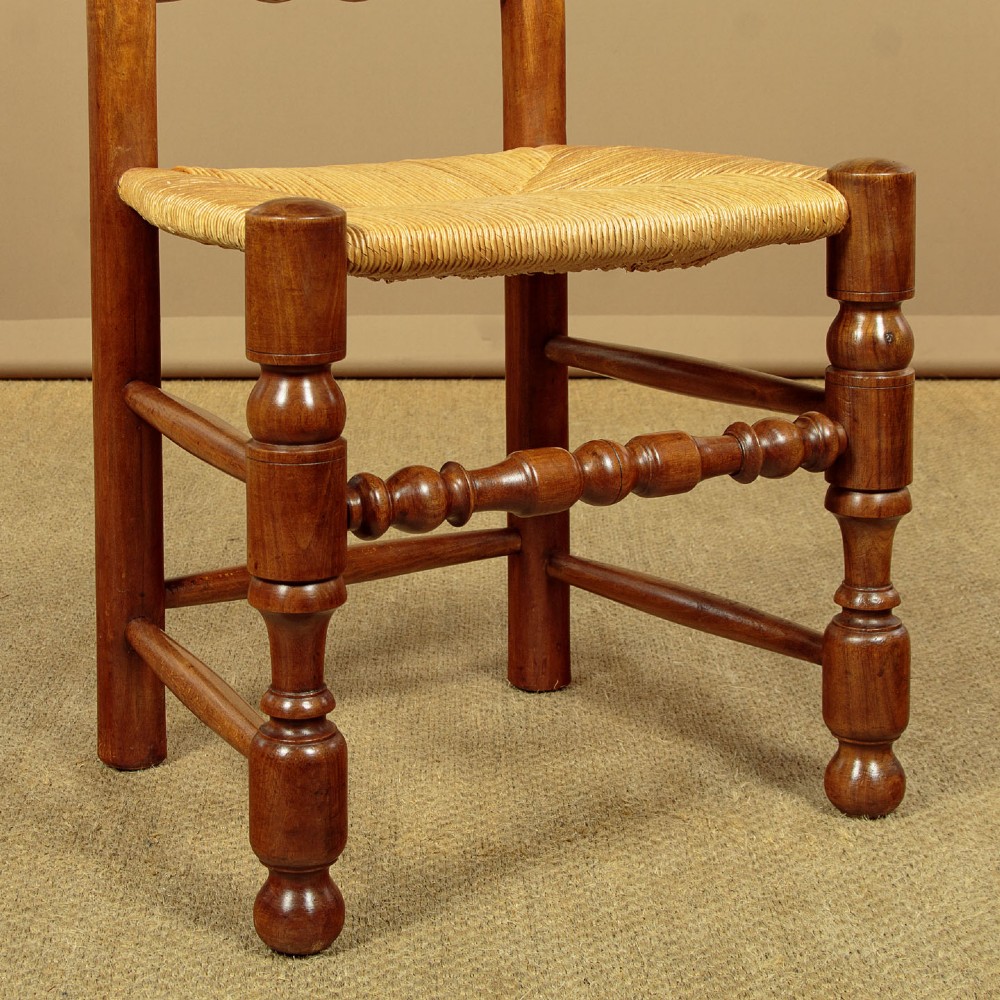 A set of six wooden ladderback dining chairs featuring wavy back slats, turned front legs, and woven rush seats. View IX