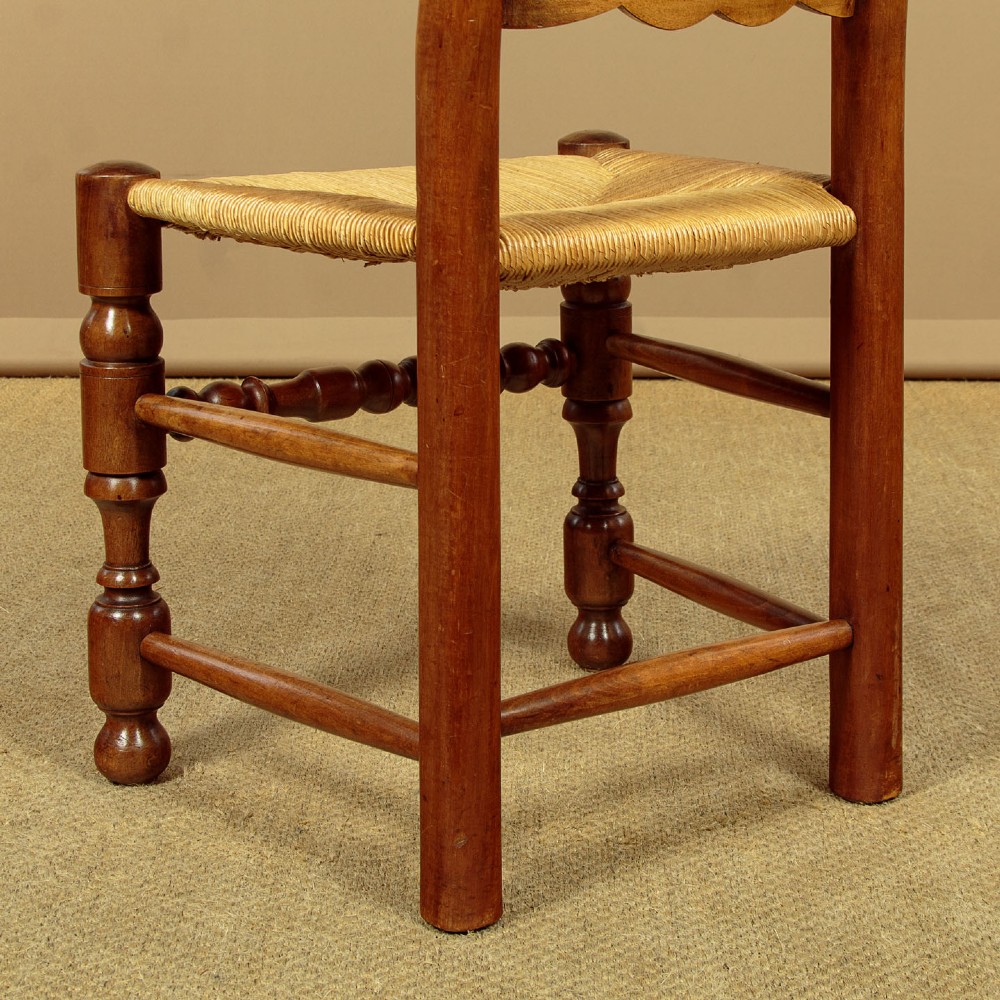 A set of six wooden ladderback dining chairs featuring wavy back slats, turned front legs, and woven rush seats. View XI