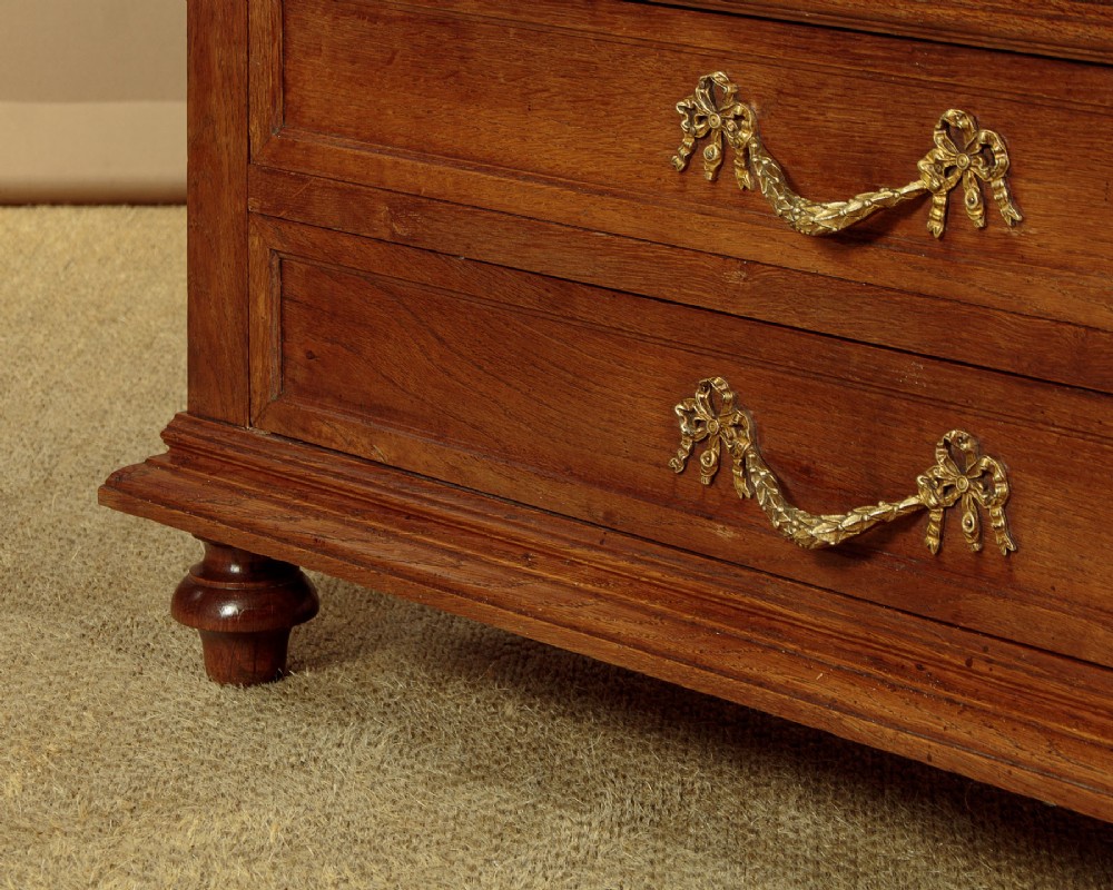 An Edwardian oak display cabinet featuring two glazed doors with gilt rosette mounts, a mirrored interior back, and two drawers at the base with swag handles. View XII