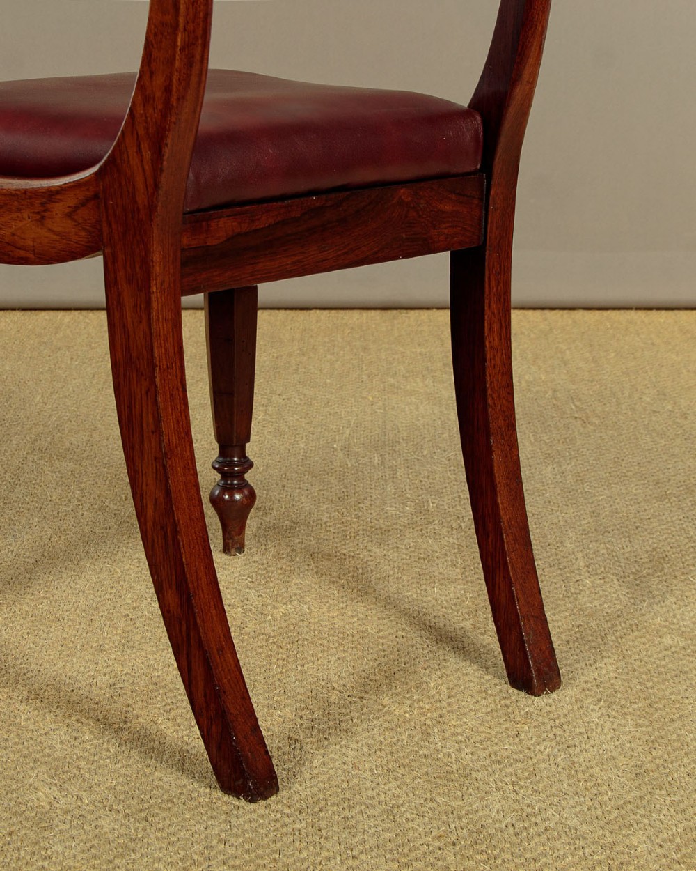 A set of four Regency rosewood dining chairs with carved scroll crest rails, turned front legs, and deep red leather drop-in seats. View XV