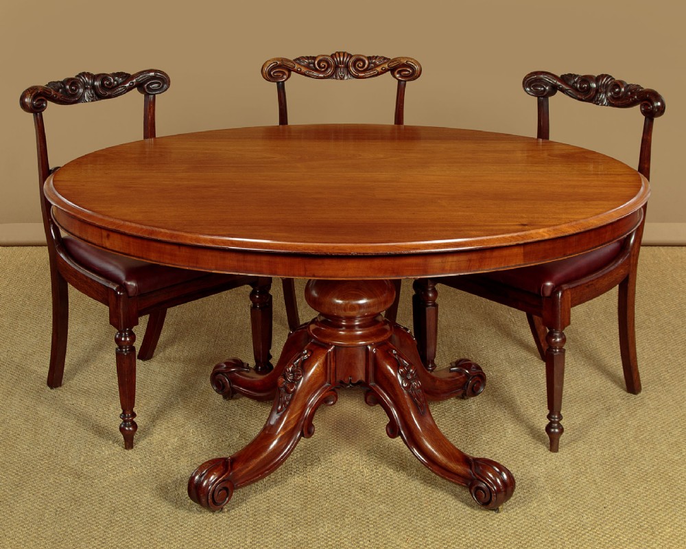 An oval mahogany pedestal dining table featuring a carved quadruped base with scroll feet. View II