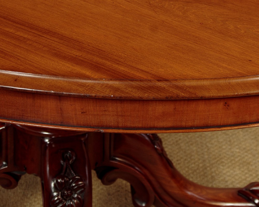 An oval mahogany pedestal dining table featuring a carved quadruped base with scroll feet. View IV