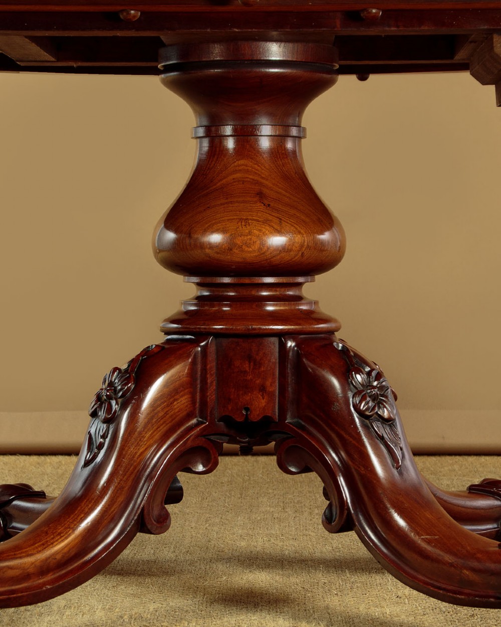 An oval mahogany pedestal dining table featuring a carved quadruped base with scroll feet. View V