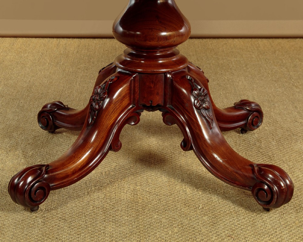 An oval mahogany pedestal dining table featuring a carved quadruped base with scroll feet. View VI