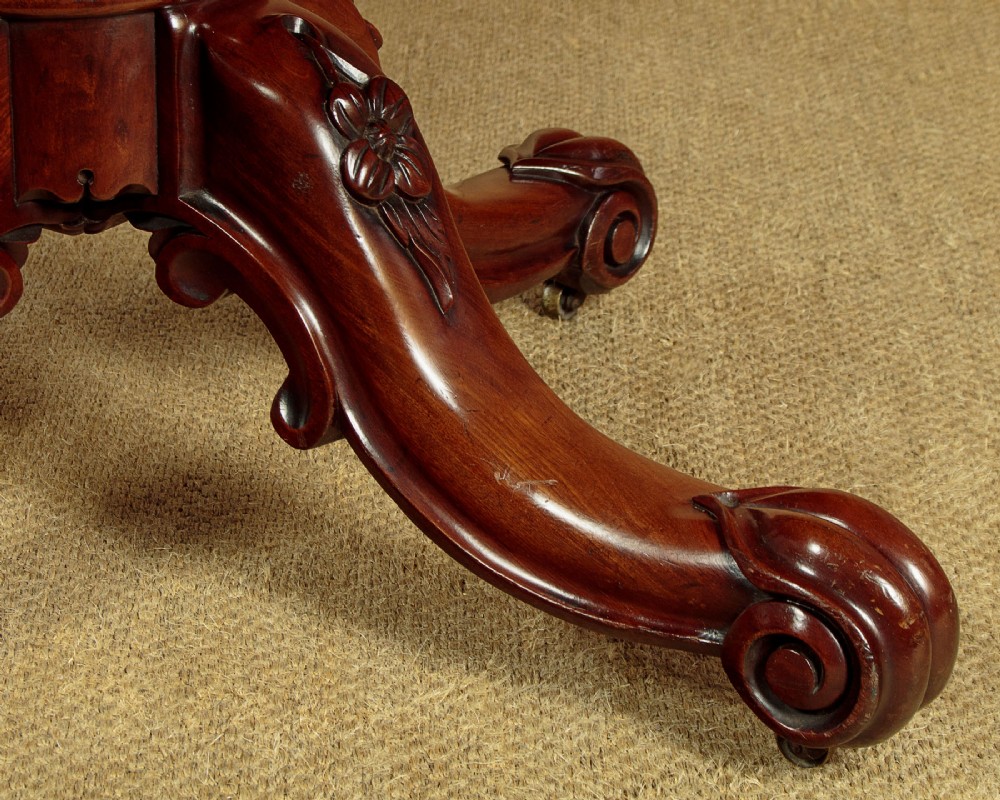 An oval mahogany pedestal dining table featuring a carved quadruped base with scroll feet. View VII