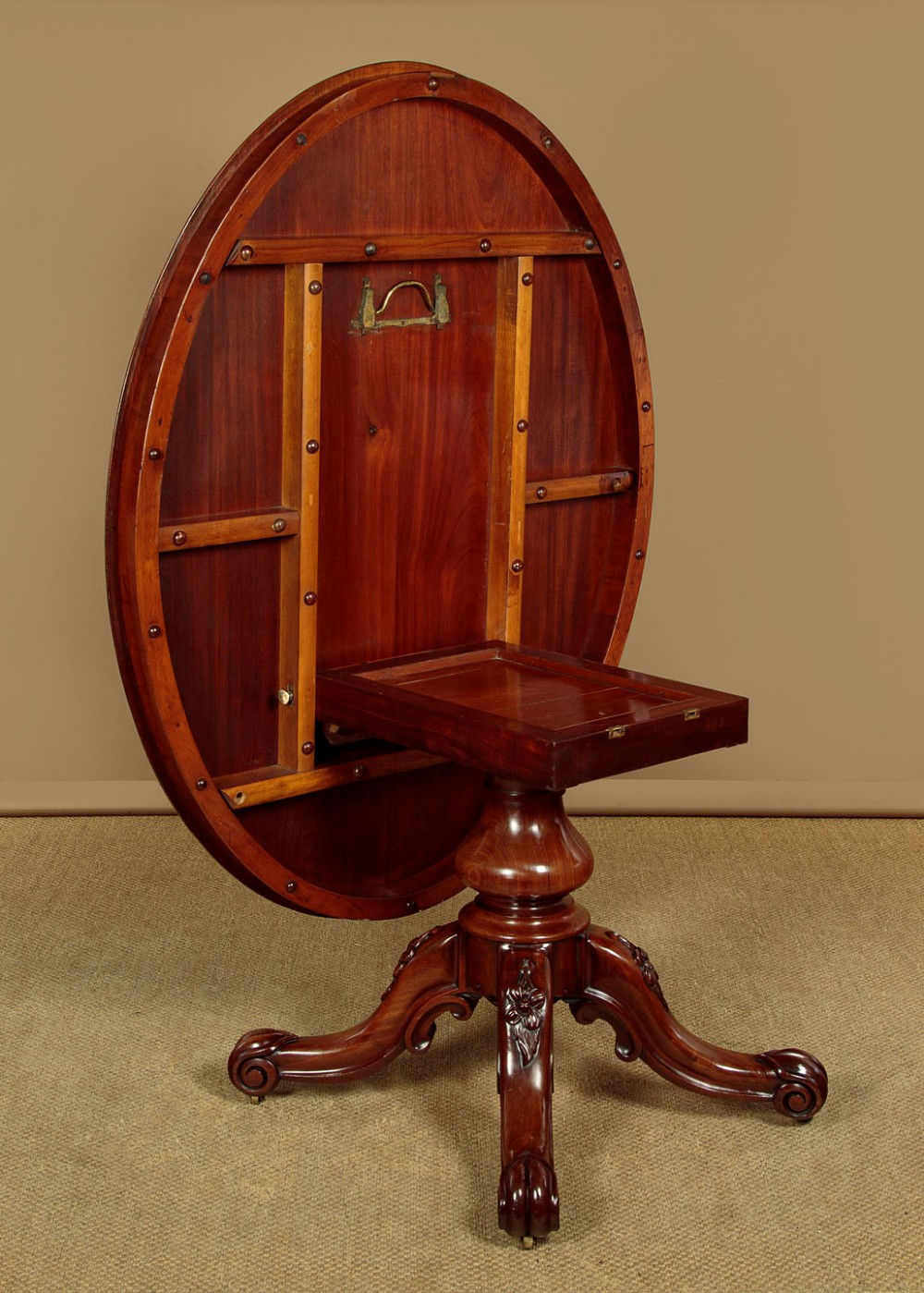 An oval mahogany pedestal dining table featuring a carved quadruped base with scroll feet. View VIII