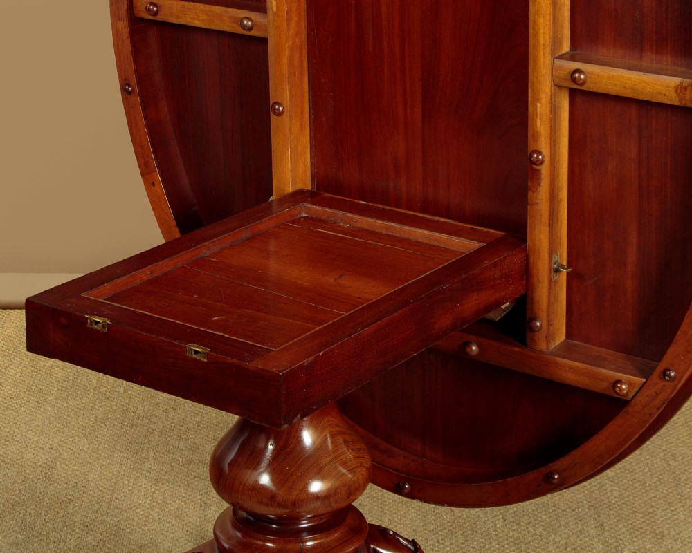 An oval mahogany pedestal dining table featuring a carved quadruped base with scroll feet. View XI