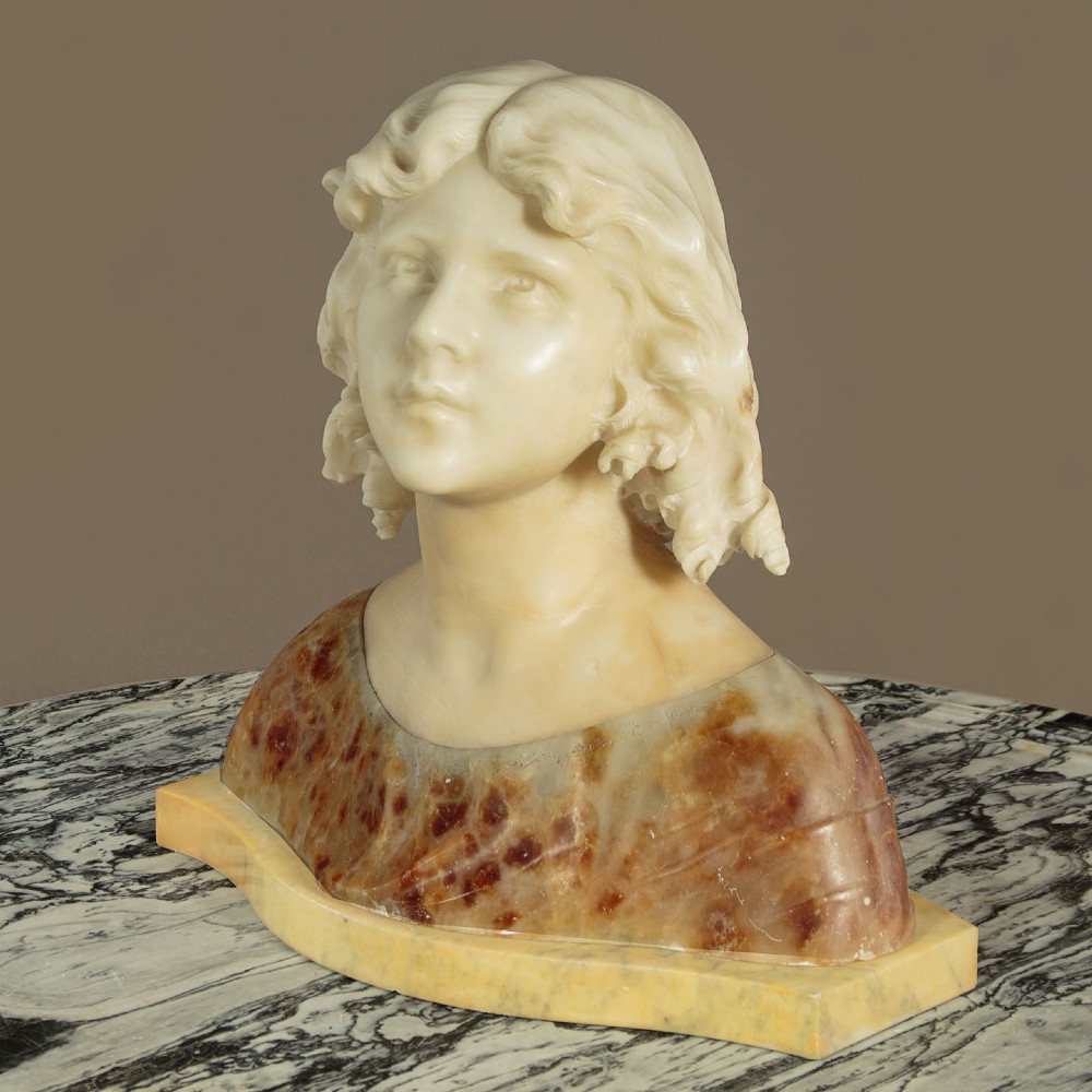 A carved alabaster bust depicting a young woman with shoulder-length wavy hair, wearing a dark amber stone dress on a matching plinth base. View III
