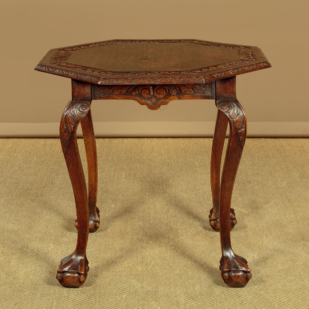 An octagonal dark carved oak side table featuring cabriole legs and carved ball and claw feet. View III