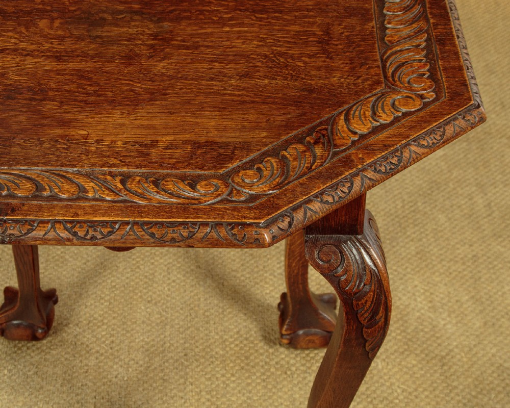 An octagonal dark carved oak side table featuring cabriole legs and carved ball and claw feet. View V