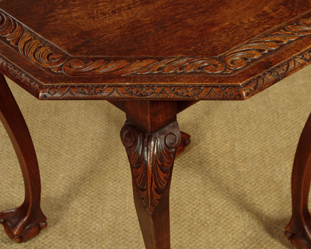 An octagonal dark carved oak side table featuring cabriole legs and carved ball and claw feet. View VI
