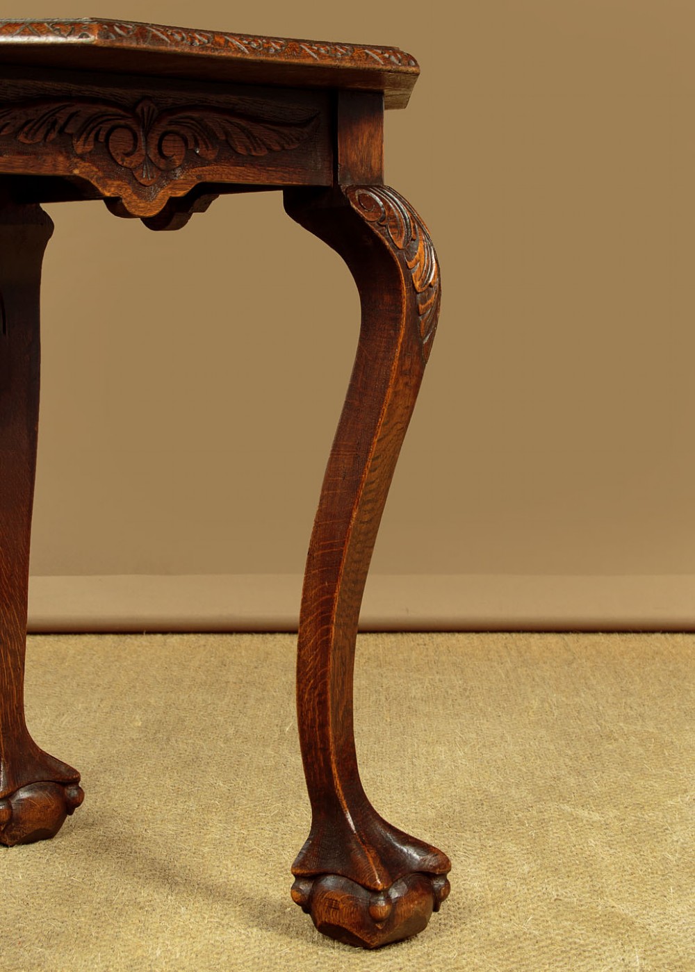 An octagonal dark carved oak side table featuring cabriole legs and carved ball and claw feet. View VIII