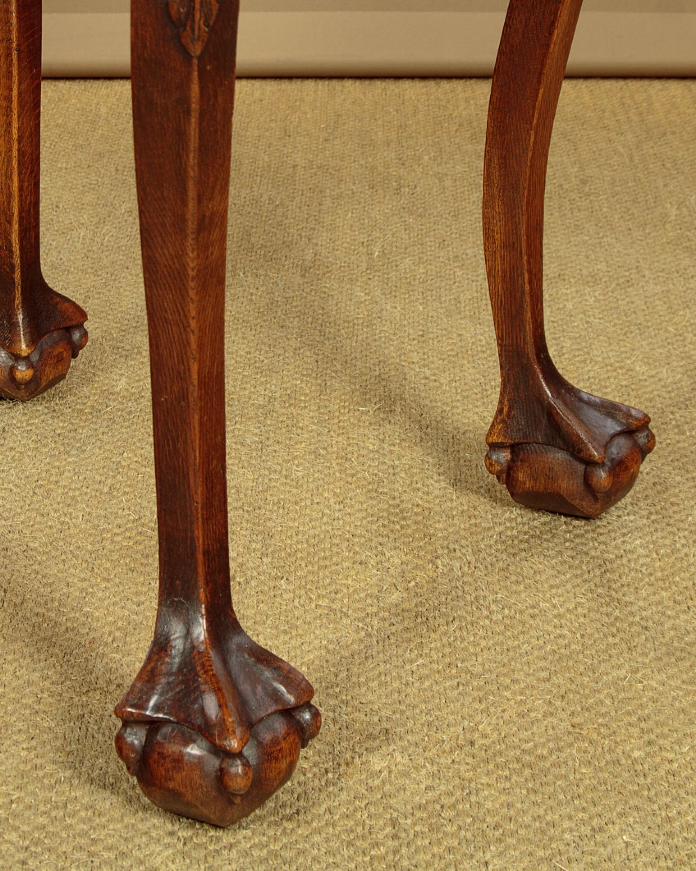 An octagonal dark carved oak side table featuring cabriole legs and carved ball and claw feet. View IX