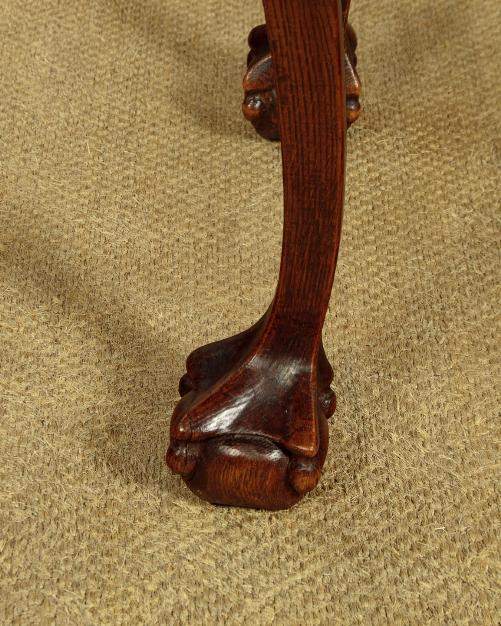 An octagonal dark carved oak side table featuring cabriole legs and carved ball and claw feet. View X