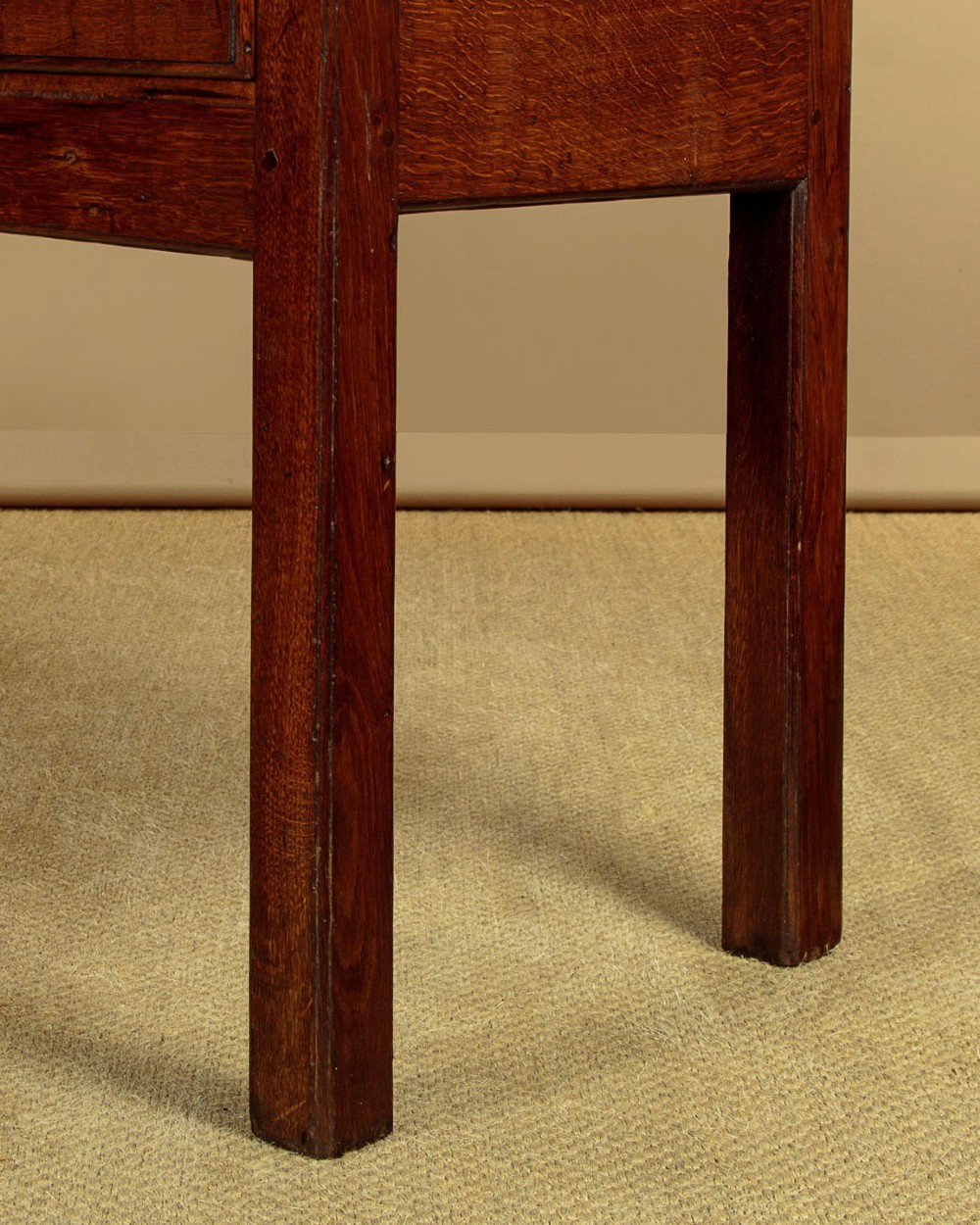 A Georgian dark oak dresser base featuring three drawers with brass handles, set on straight legs. View XI