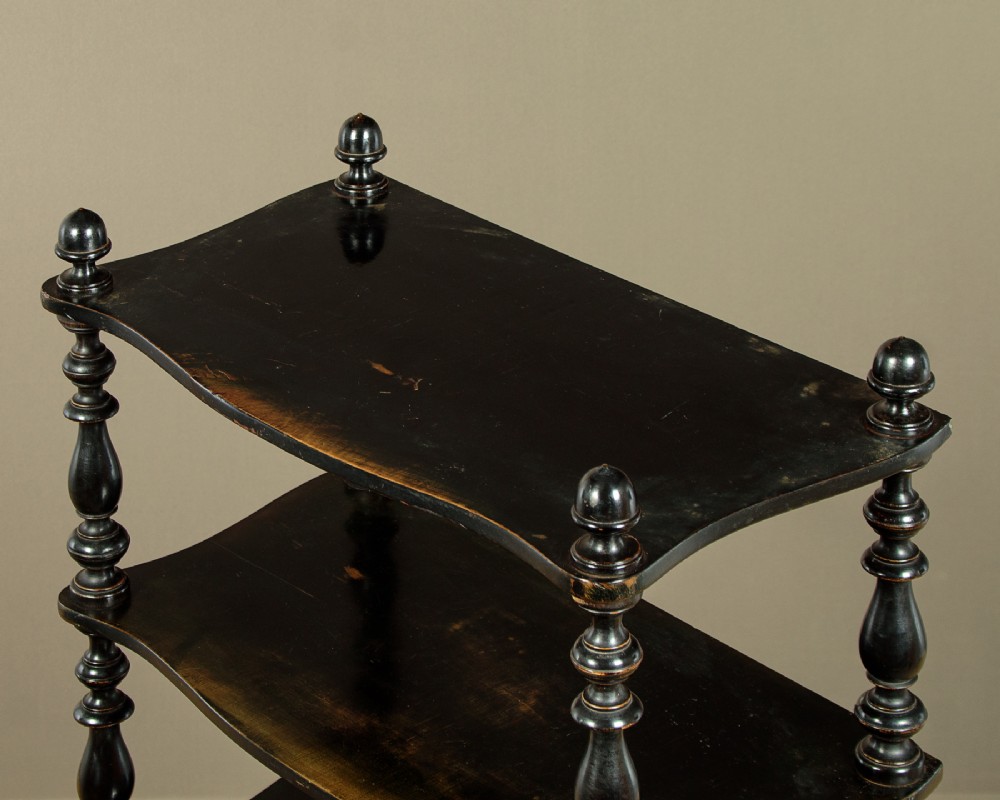 A tall mid-Victorian six-tier ebonised wood dumb waiter with turned spindle supports and finial caps. View V