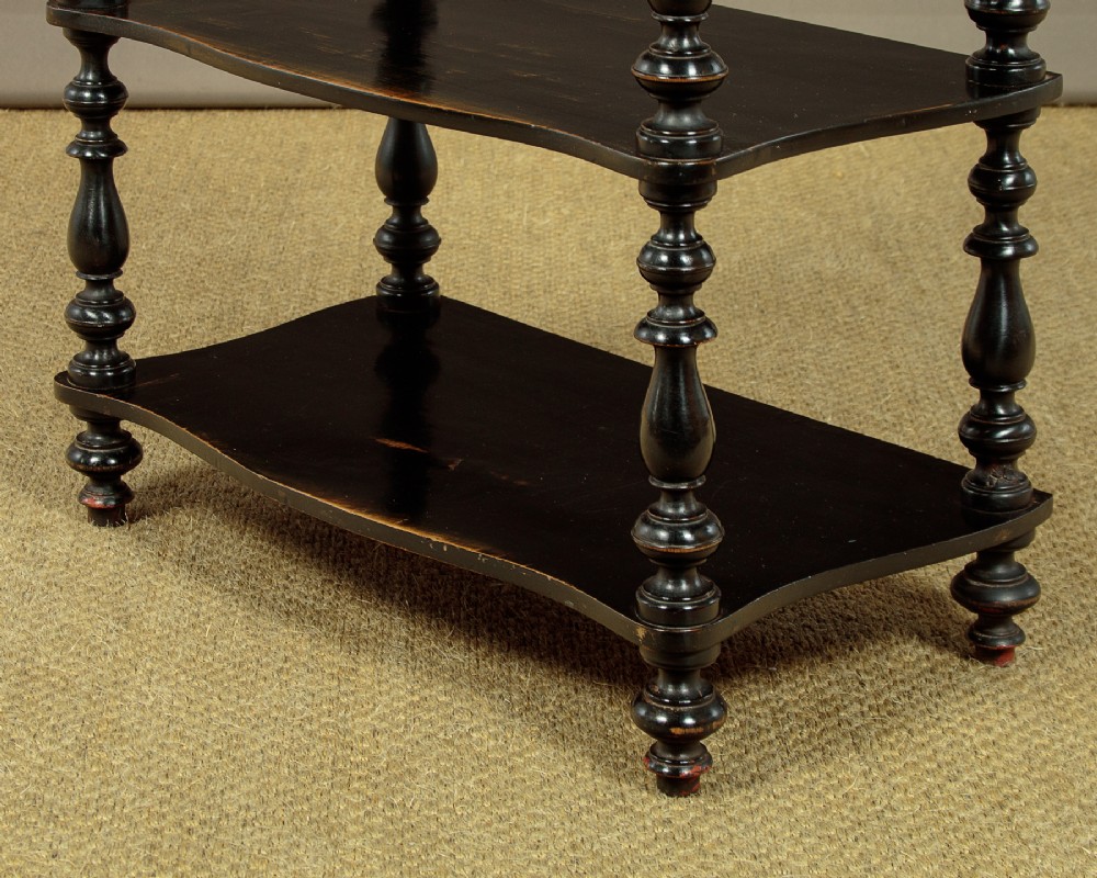 A tall mid-Victorian six-tier ebonised wood dumb waiter with turned spindle supports and finial caps. View IX