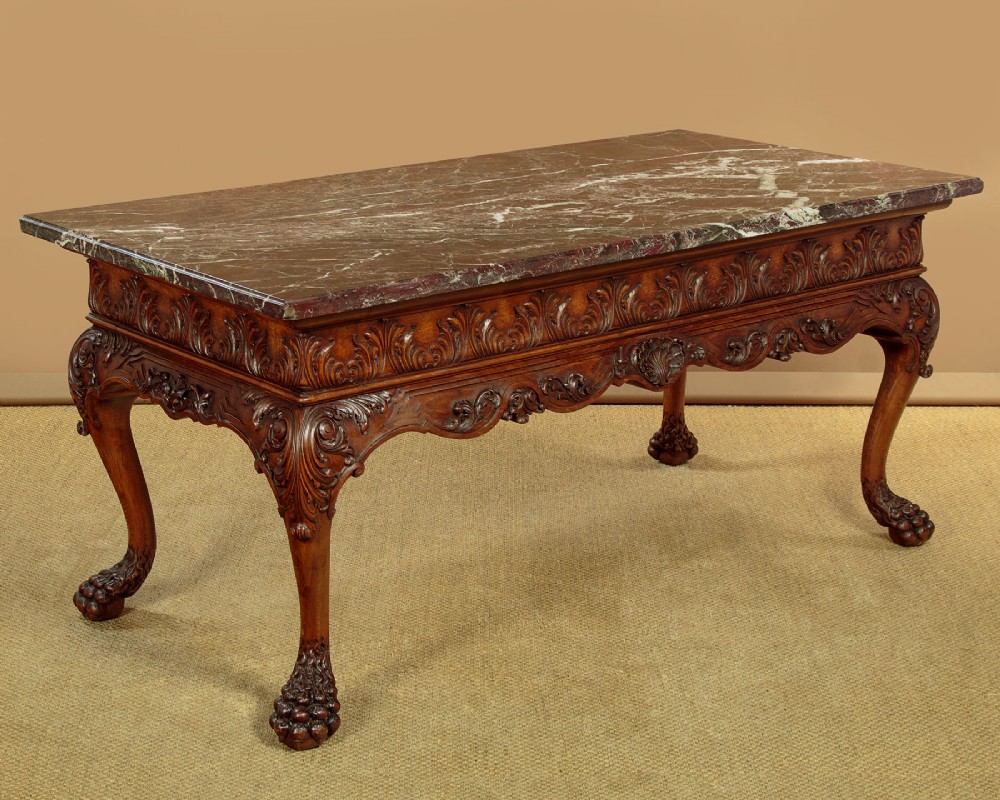 A George II style side table featuring a carved wooden frame with cabriole legs, ball and claw feet, and a polished dark marble top.