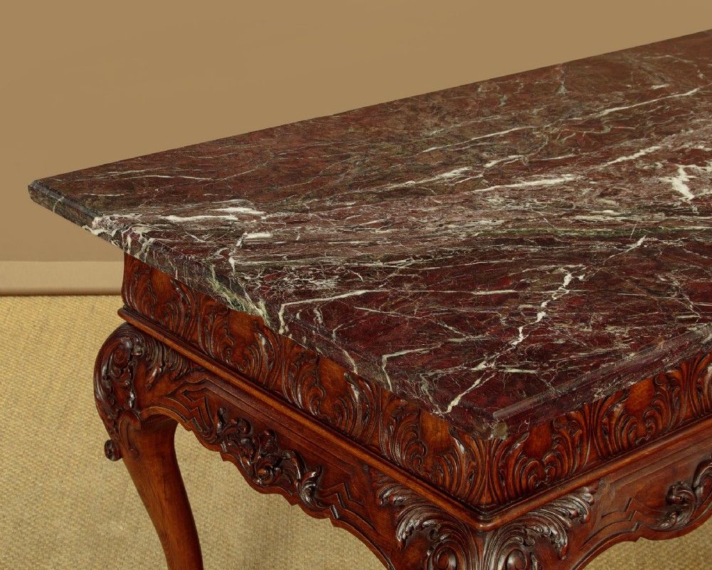 A George II style side table featuring a carved wooden frame with cabriole legs, ball and claw feet, and a polished dark marble top. View VI