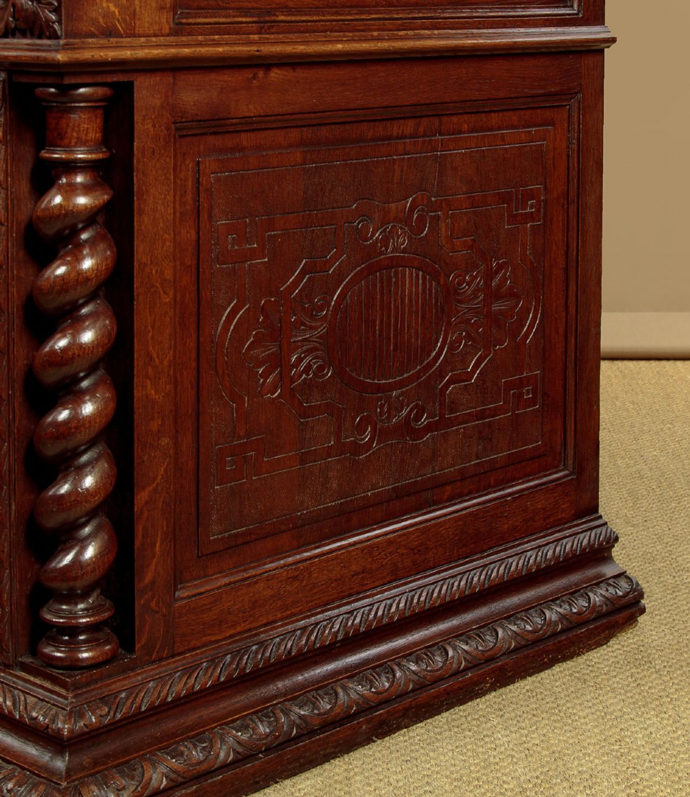 A late 19th-century dark carved oak kneehole desk featuring elaborate scrollwork carving, barley twist corner supports, and a raised superstructure with small drawers. View XIII