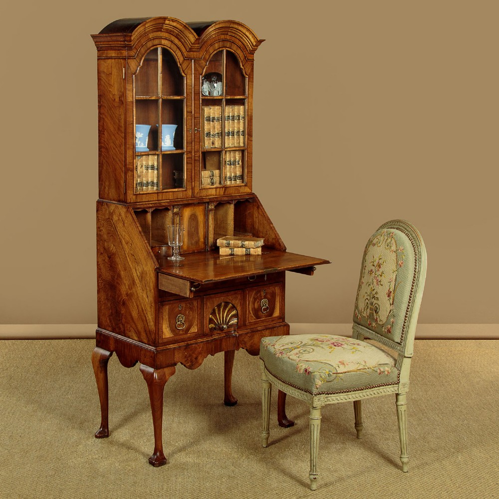 A Queen Anne style walnut bureau bookcase featuring a double-domed top, glazed upper doors, a slant-front writing slope, lower drawers with a carved shell motif, and slender cabriole legs. View II