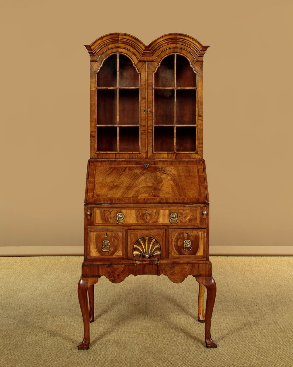 A Queen Anne style walnut bureau bookcase featuring a double-domed top, glazed upper doors, a slant-front writing slope, lower drawers with a carved shell motif, and slender cabriole legs. View III