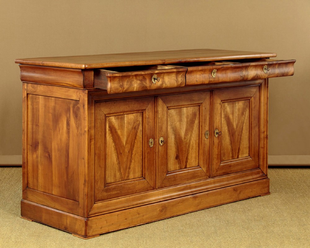 A 19th-century French cherrywood enfilade featuring three drawers over three panelled doors with geometric wood grain and brass escutcheons. View II