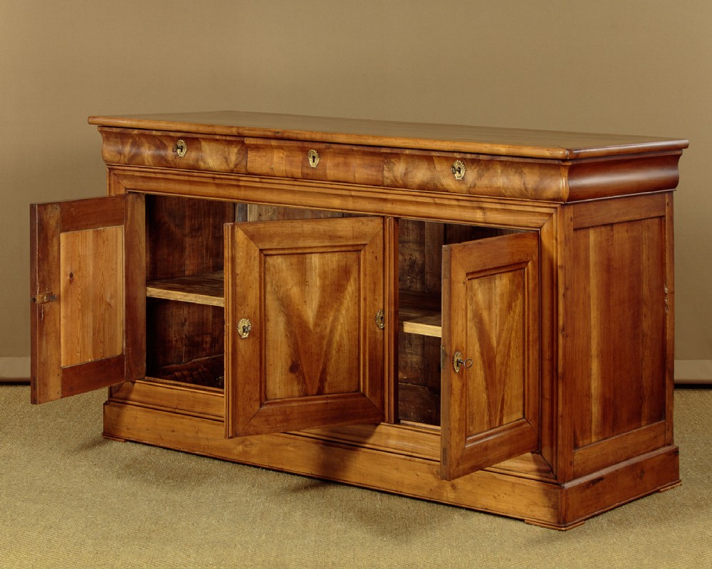 A 19th-century French cherrywood enfilade featuring three drawers over three panelled doors with geometric wood grain and brass escutcheons. View III